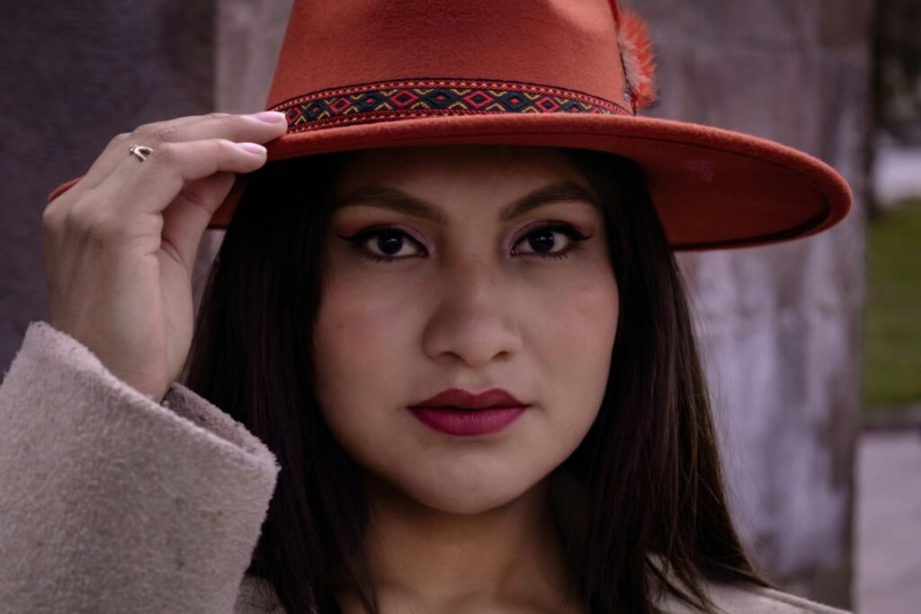 Elegant close-up portrait of woman in red hat with intricate pattern, creating a stylish look.